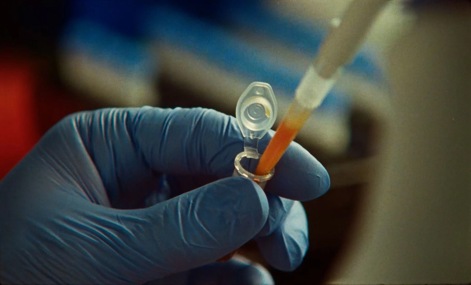 Scientist pipetting at a laboratory bench in the official Claude enzyme research video.